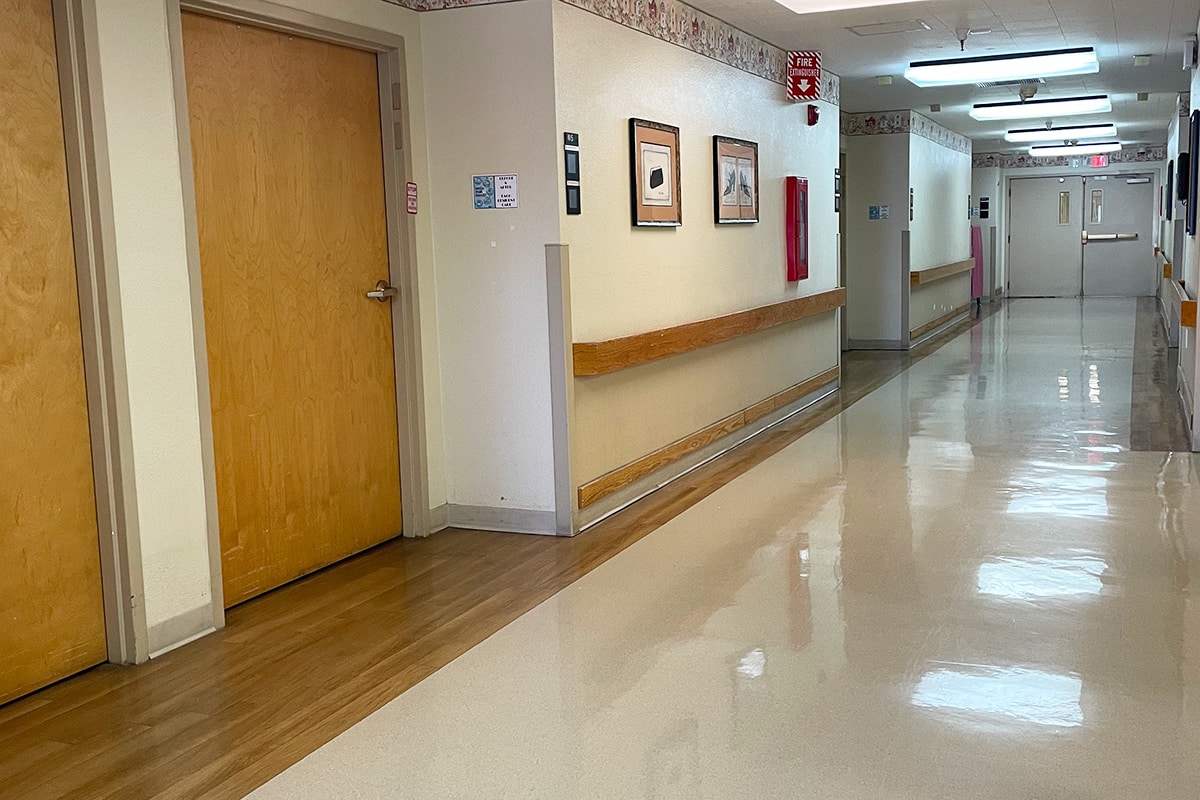 Close up of room door and wide hallway of facility