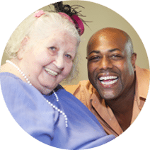 elderly woman and caregiver smiling together