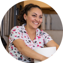smiling woman holding cleaning supplies